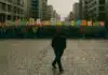 The Protest Is Over. Now What? Protest is Over: A person walks away from a large, orderly protest crowd in a city, isolated in shadow while the crowd holds colorful signs behind them.
