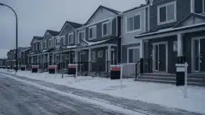 Class Conflict vs Class War in Canada | John Prince A row of identical townhouses with “FOR SALE“ signs and real estate lockboxes on every door, no signs of actual residents.