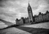 Canada's Democracy: Black and white photo of the Canadian Parliament buildings, slightly tilted, with a long shadow falling across the foreground.